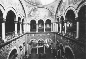 two story photo inside building with arches and columns