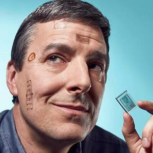 person with small electronics on face that look like tattoos